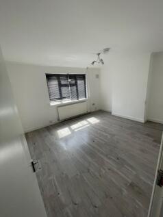 A bright, clean room with large window blinds a...