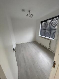 A clean and freshly painted single bedroom with...