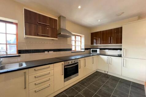 Bright, modern kitchen featuring ample countert...