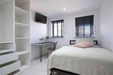 A bright and modern double bedroom featuring am...