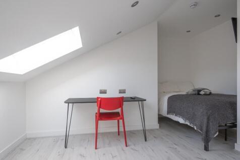 A bright and minimalist master bedroom featurin...
