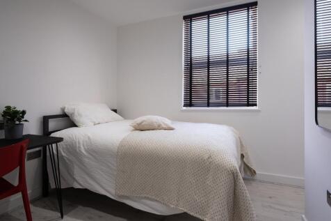 A clean and bright single bedroom featuring a n...