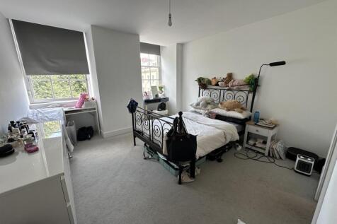 A bright and airy master bedroom featuring a la...