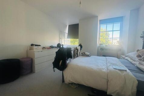 A bright and welcoming master bedroom featuring...