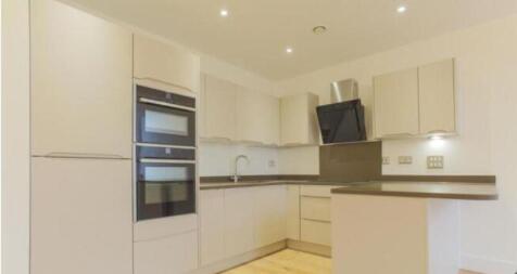 A modern kitchen featuring sleek white cabinets...
