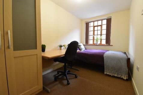 A neat and inviting single bedroom featuring a ...