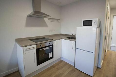 Bright and modern kitchen featuring white cabin...