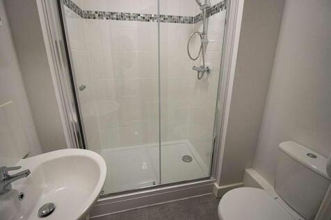 A clean and modern bathroom featuring a glass-e...