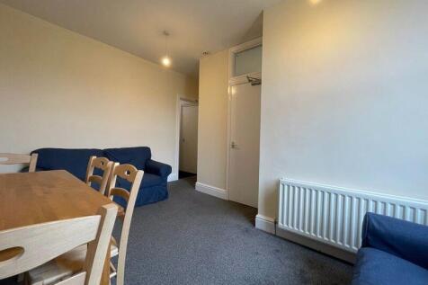 A bright and tidy living room featuring comfort...