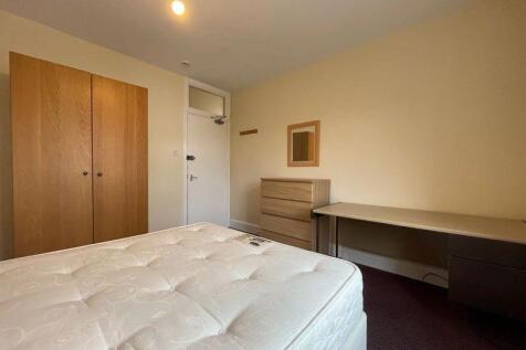 A tidy single bedroom featuring a comfortable m...