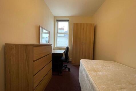 A neat and functional single bedroom featuring ...