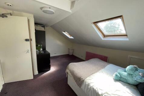 Cozy double bedroom with a slanted ceiling and ...