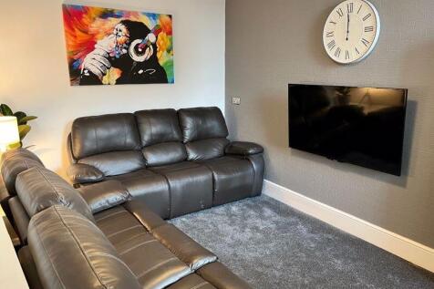 A cozy and contemporary living room featuring p...