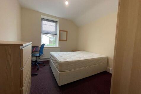 A neat and simple bedroom featuring a comfortab...
