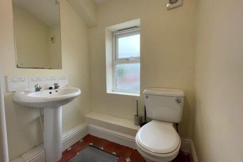 A clean and simple toilet room featuring a whit...