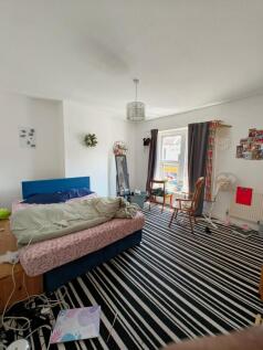 Bright double bedroom with a large window allow...