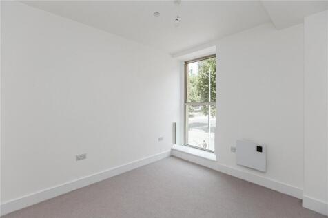 A bright and clean single bedroom featuring a l...