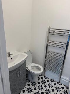 A clean and modern single toilet room featuring...