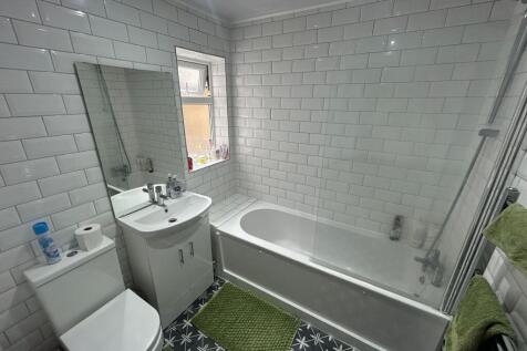 Bright and modern bathroom suite featuring a cl...