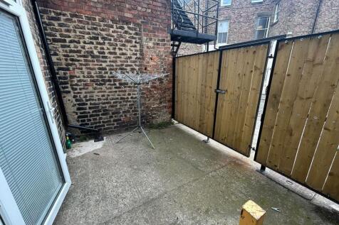 A private outdoor garden space enclosed by bric...