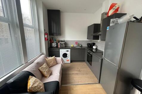 Modern kitchen with dark cabinetry, a washing m...