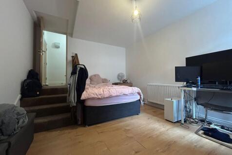 A cozy single bedroom featuring a comfortable b...