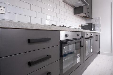 Modern kitchen featuring sleek cabinetry, ample...