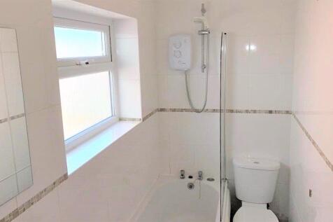 Bright and clean bathroom featuring a bathtub a...