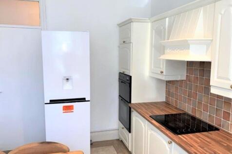 Bright and tidy kitchen featuring modern white ...
