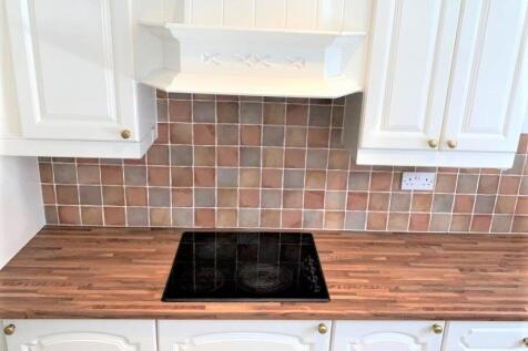 Bright and tidy kitchen with modern electric ho...