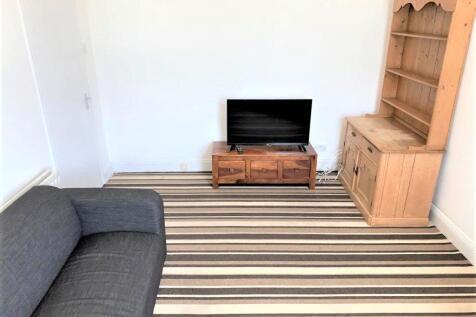 A cozy living room featuring a comfortable dark...
