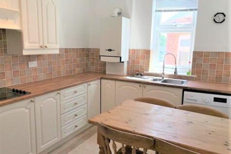 A bright and tidy kitchen featuring white cabin...
