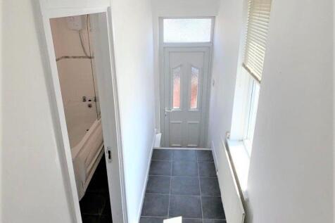 Bright and clean hallway featuring modern tiled...
