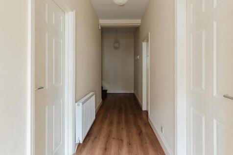 A well-maintained hallway featuring clean woode...