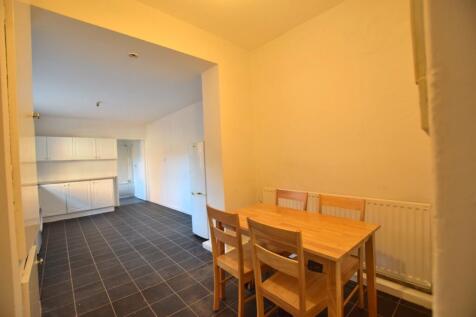 A spacious kitchen area featuring a wooden dini...