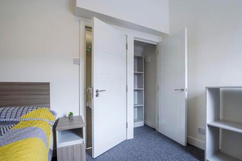 A bright and tidy double bedroom featuring a do...