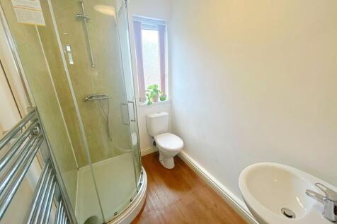 A clean and bright bathroom featuring a curved ...