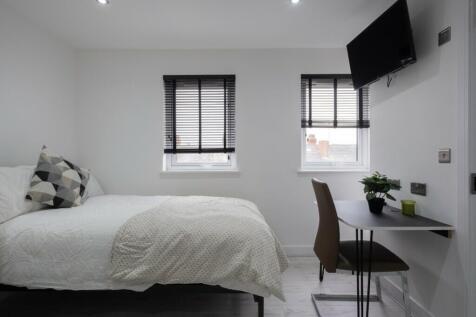 This cozy double bedroom features ample natural...