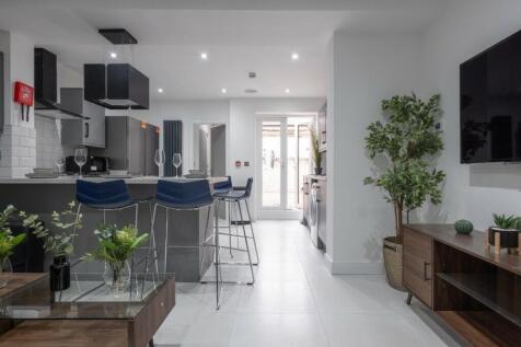 Modern kitchen featuring stylish bar seating, s...