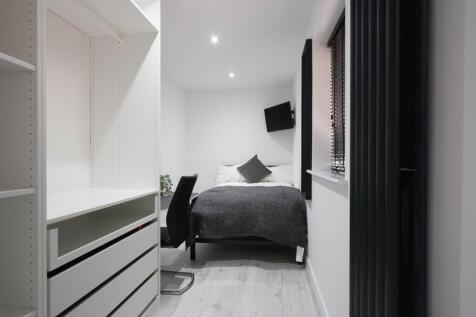 A modern double bedroom featuring a cozy bed, s...