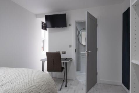 This modern double bedroom features a comfortab...