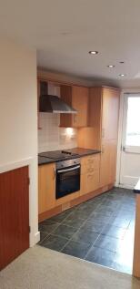 A modern kitchen with wooden cabinetry, a built...