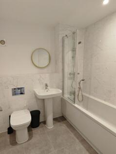 A modern bathroom suite featuring a clean white...