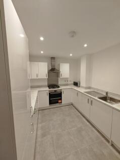 A modern, clean kitchen featuring sleek white c...