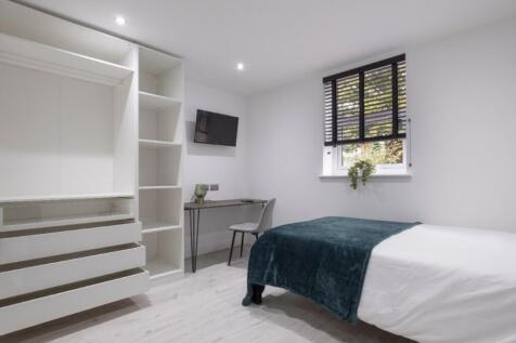 This stylish double bedroom features a comforta...