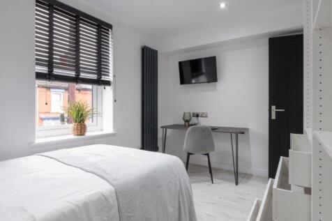 This stylish double bedroom features a comforta...