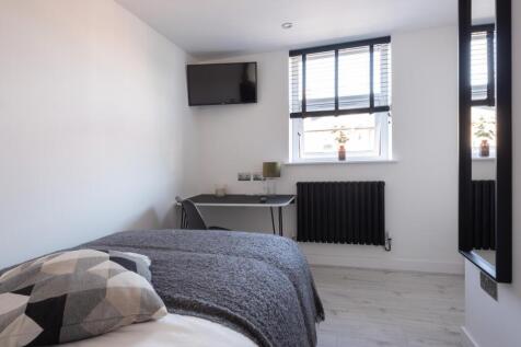 This cozy double bedroom features a comfortable...