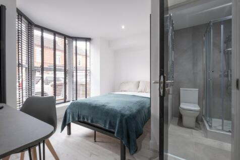 This inviting double bedroom features a comfort...