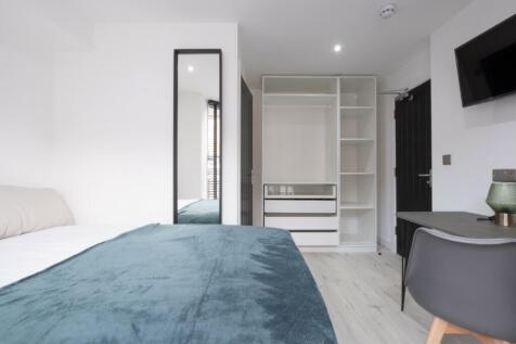 This stylish double bedroom features a cozy bed...