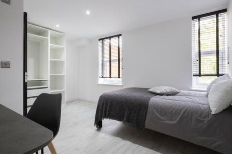 This spacious double bedroom features large win...